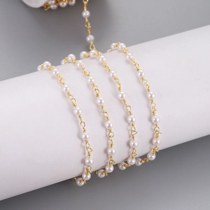 Detail of gold wire wrapped pearl chain showing handmade jewelry DIY texture on white roll