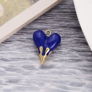 Detail of molten lava heart pendant with blue enamel drip and gold metal base