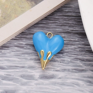 Macro detail of sky blue enamel heart pendant with golden lava drip effect on wood surface