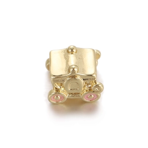 Macro detail of a gold-plated pumpkin carriage charm with pink enamel wheels for DIY jewelry