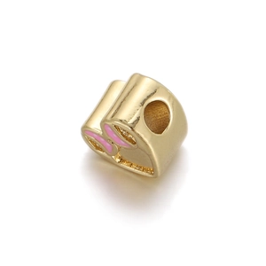 Macro detail of gold-plated copper bead with pink enamel butterfly for DIY jewelry