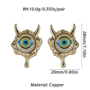 Detail view of Evil Eye devil earrings with gold horns and copper metal tassels