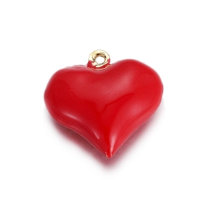Dettaglio di un ciondolo a cuore rosso lucido con anello dorato per creazioni di gioielli