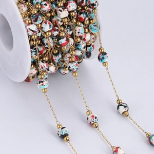 Golden stainless steel beaded chain with multi-color beads on a white plastic spool