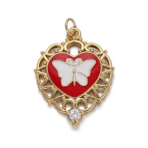 Macro detail of heart pendant with red enamel, white butterfly, and gold filigree border