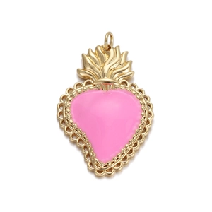Dettaglio del ciondolo a cuore dorato con smalto rosa e decorazione a forma di fiamma