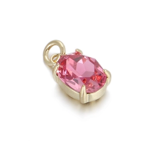 Detail of pink oval faceted stone set in gold-tone copper pendant for jewelry making