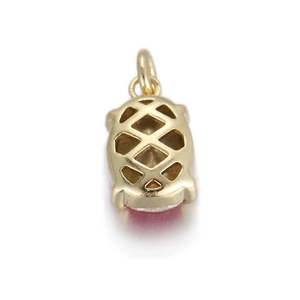 Close-up of gold geometric pendant with red gemstone and hollow rhombus back detail