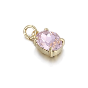 Detailed macro view of a pink oval cut gemstone pendant set in a golden four-prong mount