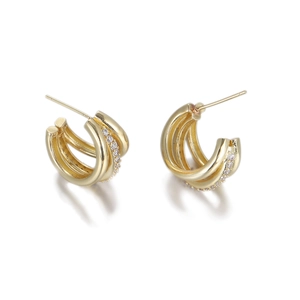 Detail of gold C-shaped hoop earrings with triple-layered metal bands and micro-set zircons