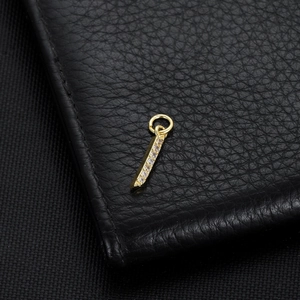 Detail of 14K gold plated Arabic letter pendant with micro-pave crystals on black leather