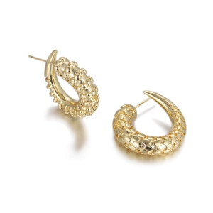 Detail of gold-plated C-shaped earrings featuring a dense caviar-bead textured surface