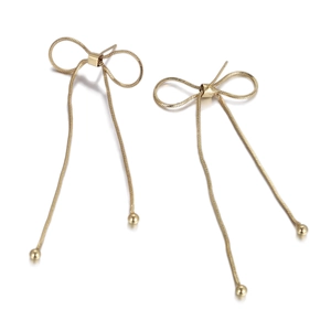 Close-up of gold bow earrings with long snake chains and hanging metallic beads