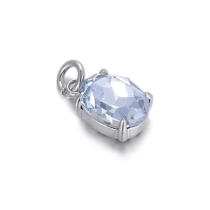 Macro detail of oval light blue zircon pendant with silver four-prong setting
