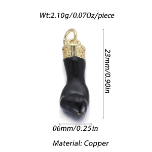 Detalle de un colgante de bota de esmalte negro de 23mm con detalles de cobre dorado y grabado