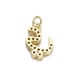 Macro detail of a 14K gold plated Arabic letter pendant with zircon setting holes