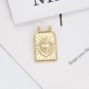 Detailed close-up of a 14K gold-plated rectangular charm featuring a sacred heart relief
