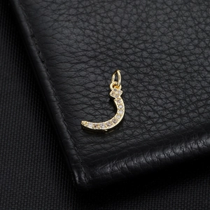 Macro view of gold plated Arabic letter pendant with micro-pave zircon crystals
