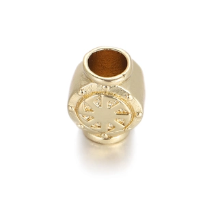 Makro-Detail von goldener zylindrischer Charm-Perle mit Sonnenmuster und Mittelloch