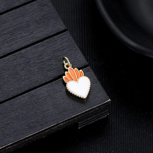 Detail of heart pendant with white enamel and orange petals on gold metal base