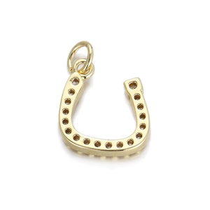 Macro detail of horseshoe charm in 14K gold plated finish with textured surface for DIY jewelry
