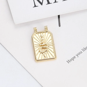 Detail of a 14K gold plated rectangular pendant with embossed snake and sunburst motif