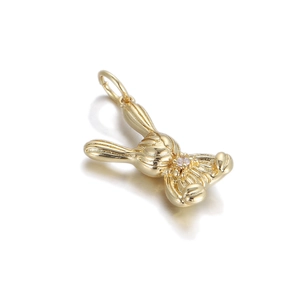 Detailed view of a gold rabbit charm with a bow and sparkling crystal accent