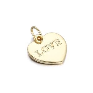 Close-up of golden heart pendant with 3D Love engraving and polished metal finish