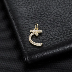 Macro detail of 14K gold plated Arabic letter pendant with pavé cubic zirconia