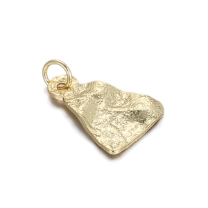 Macro detail of gold-plated lava hammer texture pendant with polished irregular surface