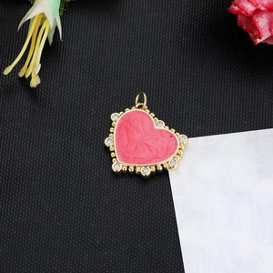 Macro shot of 14K gold-plated heart pendant with pink enamel and sparkling zircons