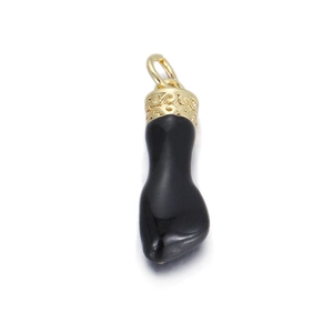 Makroaufnahme von poliertem schwarzem Zahnanhänger mit goldenen Sonnenmustern und Relief