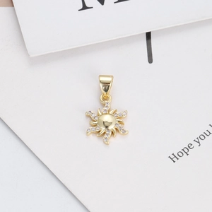 Macro detail of 14K gold plated sun pendant featuring pave white zircon stones