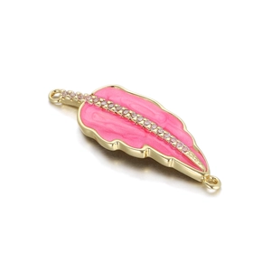Macro shot of gold leaf pendant with pink enamel and sparkling white crystals