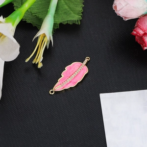 Close-up of pink enamel leaf pendant with gold frame and cubic zirconia stones
