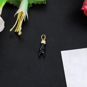 Macro shot of black enamel rock hand gesture pendant with 14K gold plated loop