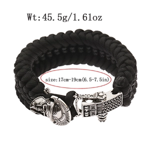 Macro detail of paracord skull bracelet showing silver knight helm buckle and woven texture