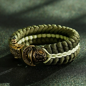 Close-up of army green paracord bracelet with bronze spartan helmet skull clasp