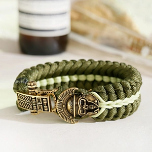 Macro shot of bronze Spartan helmet skull buckle on green paracord survival bracelet