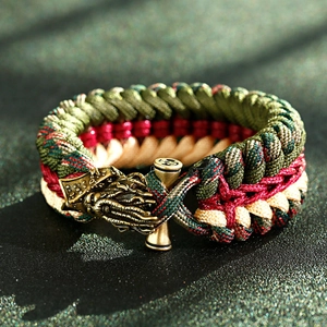 Macro detail of hand-woven paracord bracelet with vintage brass dragon buckle fastener