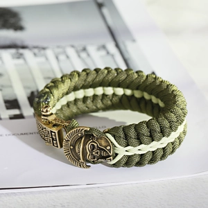 Detail of army green paracord survival bracelet featuring an antique bronze skull clasp