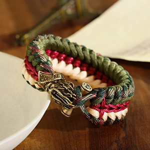 Close-up of tricolor paracord survival bracelet with detailed brass dragon head buckle