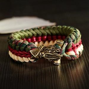 Macro shot of handcrafted paracord bracelet with a brass dragon head metal buckle
