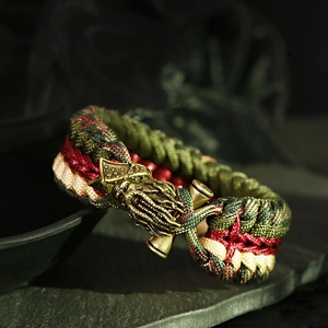Close-up of paracord bracelet with antique brass Kraken bead on dark stone
