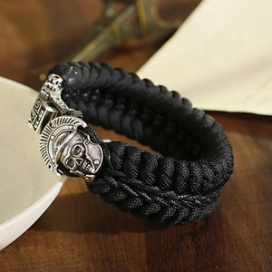 Close-up of black paracord bracelet featuring a silver gladiator skull metal clasp