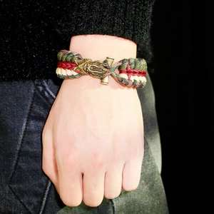 Detailed shot of olive and red paracord bracelet featuring a bronze dragon clasp