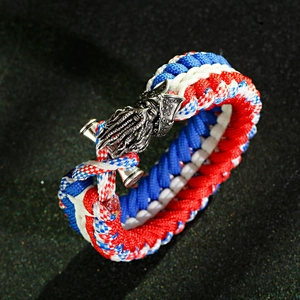 Macro shot of tricolor red white blue survival paracord bracelet with metal dragon clasp