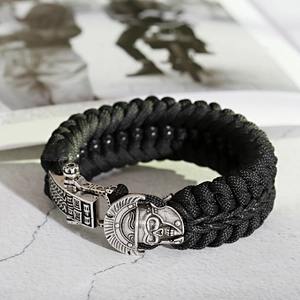Detailed view of black paracord bracelet with a silver Spartan skull helmet buckle