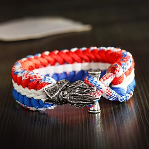 Macro detail of tricolor paracord braid and silver kraken buckle on men's bracelet