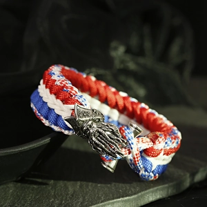 Macro detail of red white blue paracord bracelet with antique metal pirate charm